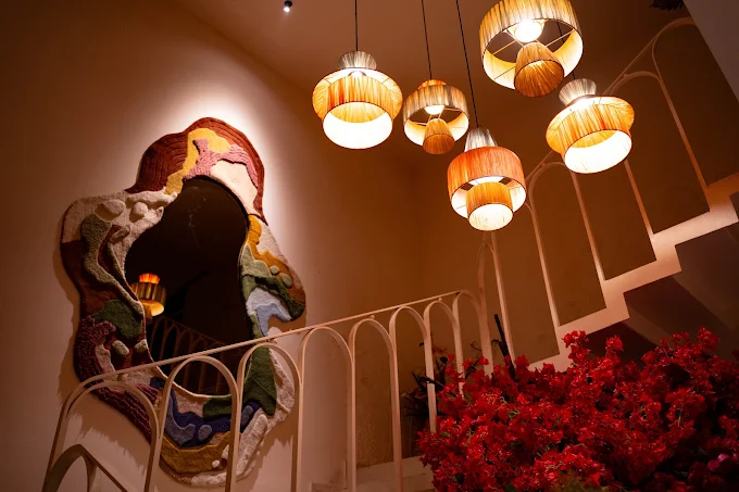 Woven pendant lights over a mural and bougainvillea in the restaurant at Stories Brew Garden