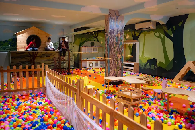 The kids' play area with a ball pit and jungle mural