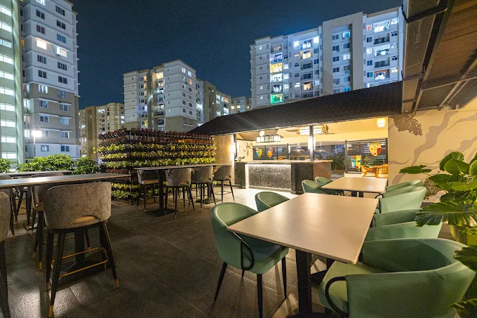 Rooftop seating along the edge with the North Bengaluru skyline behind